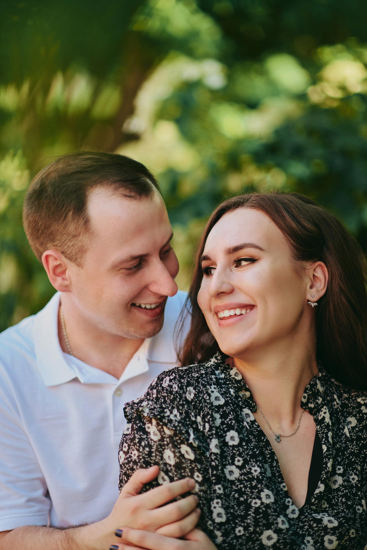 Близкий портрет улыбающейся пары среди зелени