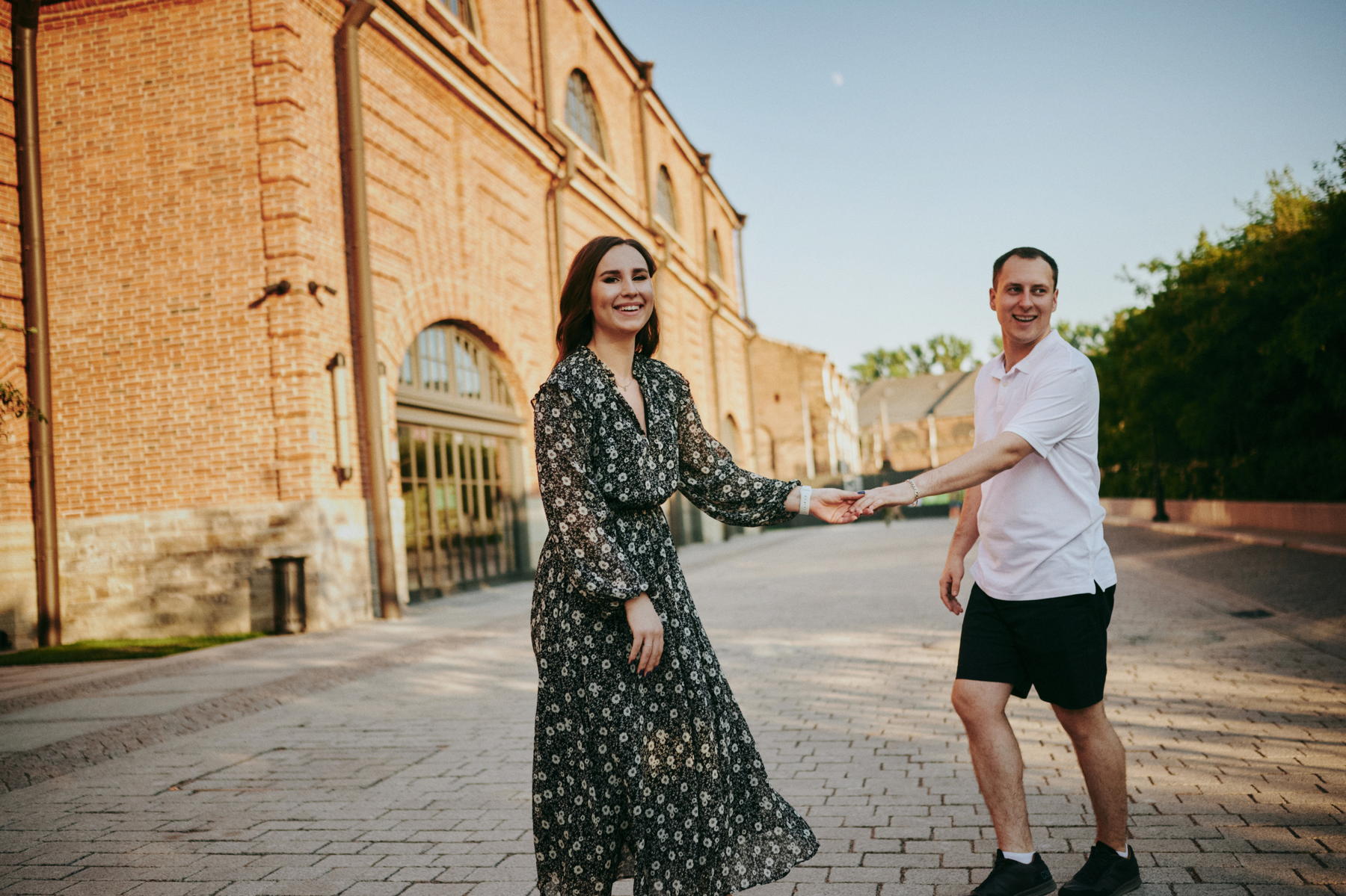 Пара улыбается в камеру, держась за руки