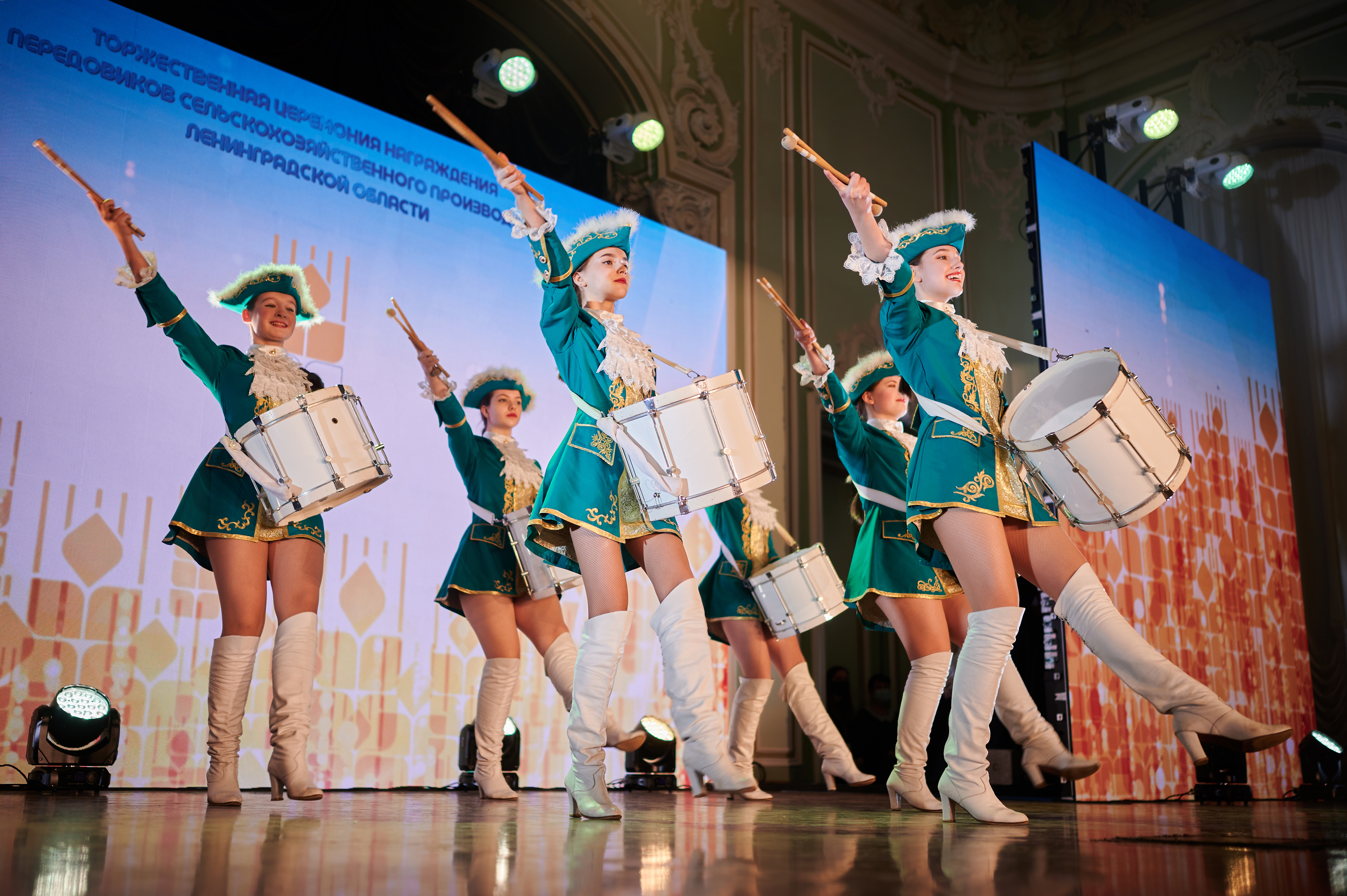 Артистки в зелёных костюмах выступают с барабанами
