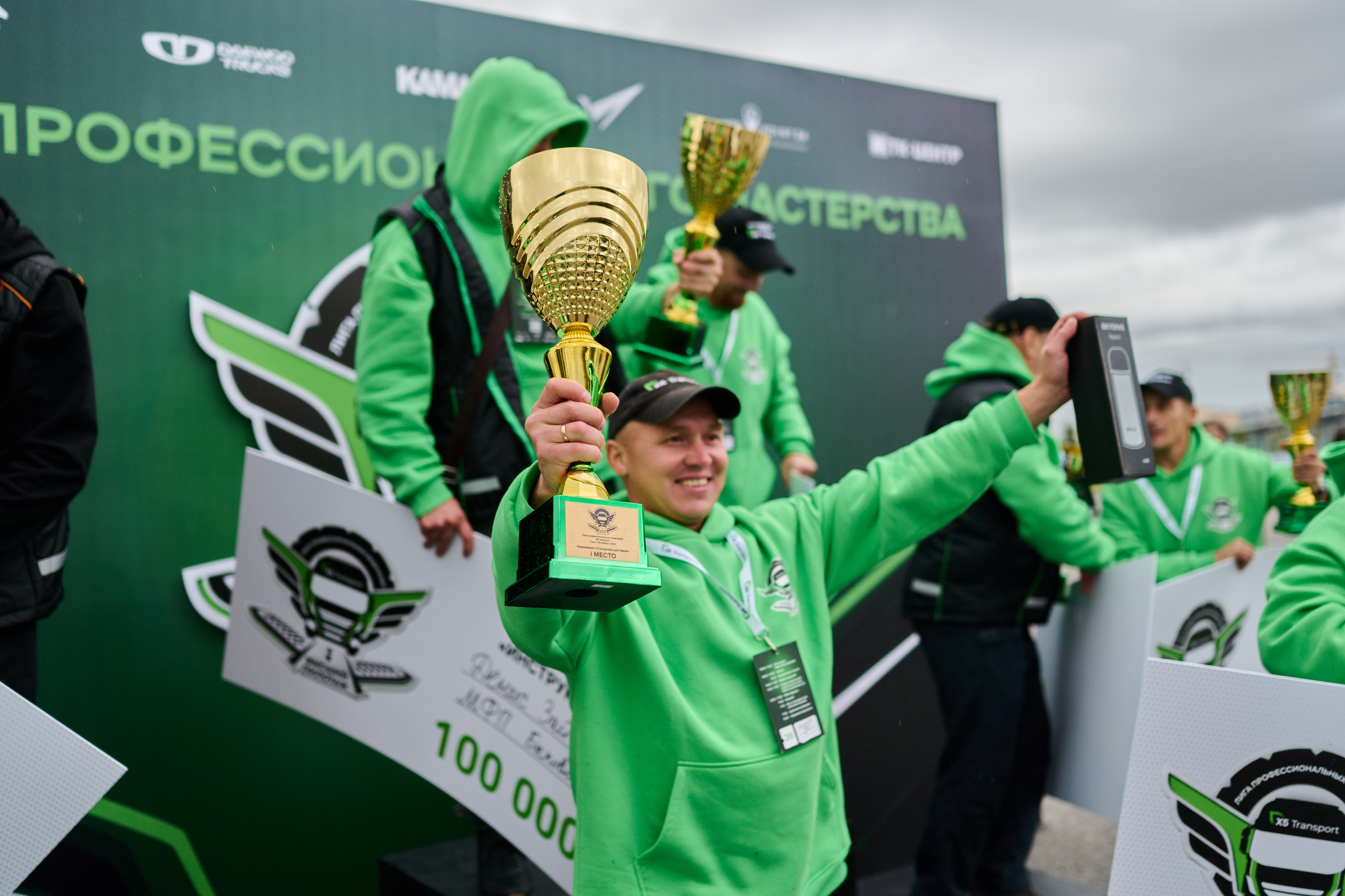 Улыбающийся победитель турнира с кубком