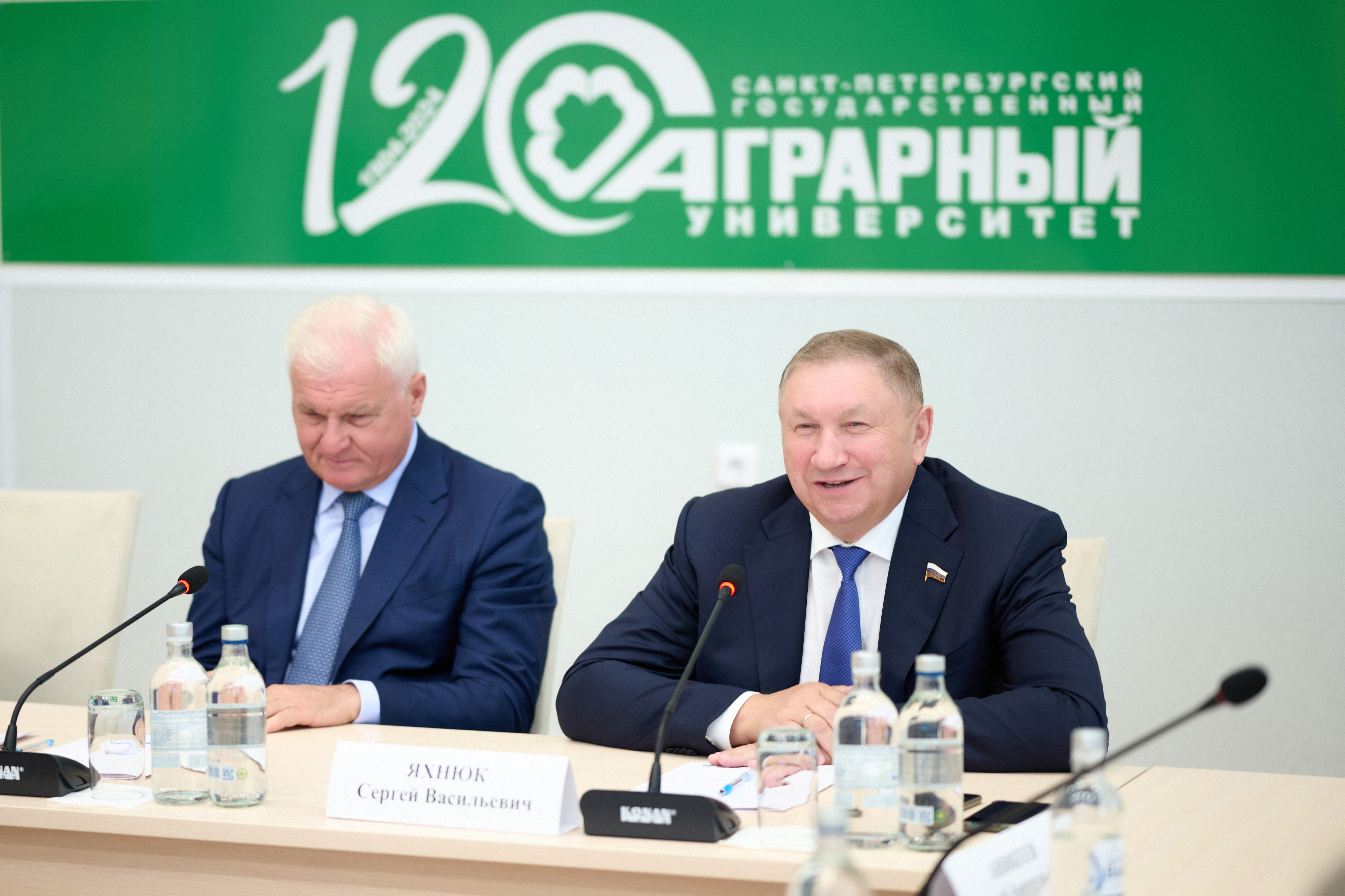 Спикеры беседуют за столом с микрофонами
