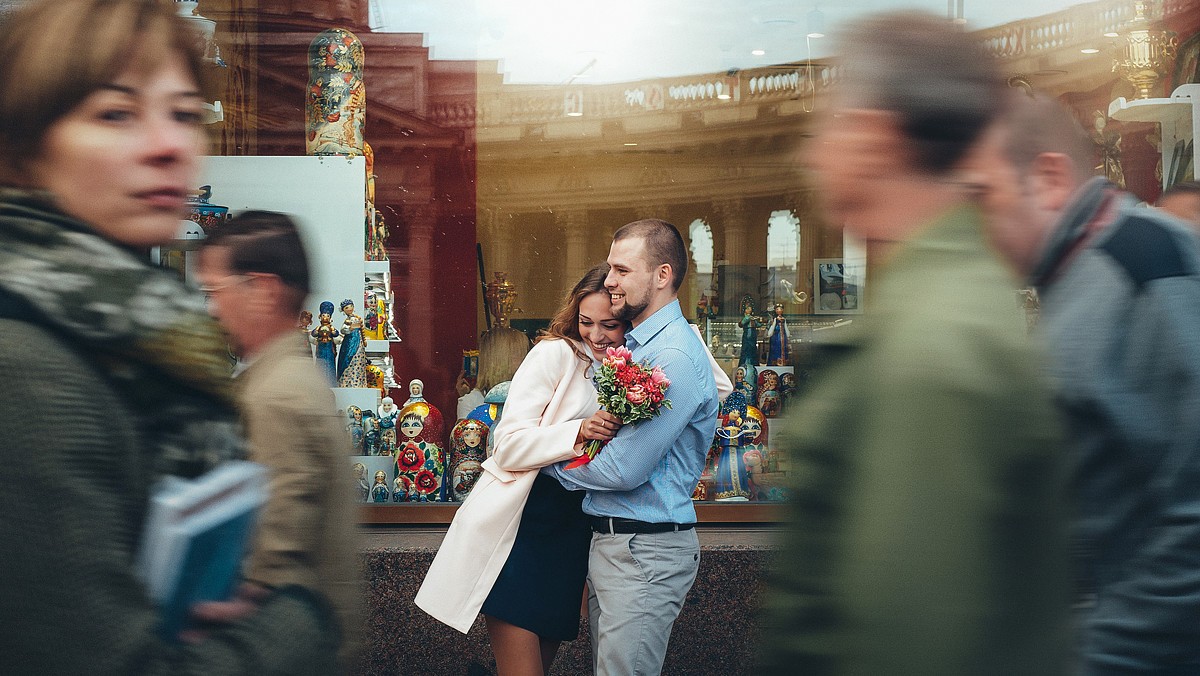 Жених несёт невесту сквозь толпу на улице